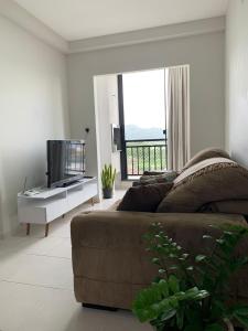 a living room with a couch and a television at Apartamento Beto Carrero Centro Penha SC in Penha +16 photos