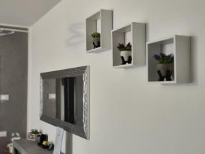 a wall mounted mirror with potted plants on it at Sempione Apartment in Lainate