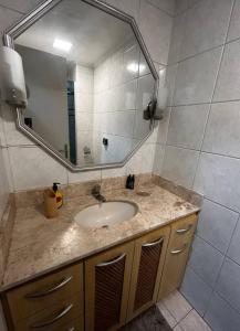 een badkamer met een wastafel en een grote spiegel bij Apartamento Pôr do Sol in Porto Alegre