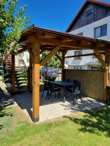 a wooden pergola with a table and chairs at Ubytování Šustovka in Třeboň