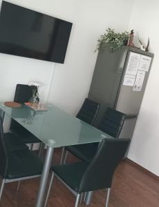 uma sala de conferências com uma mesa de vidro e cadeiras em Barackos Apartman em Tapolca