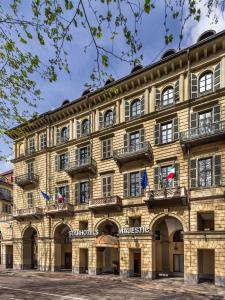 een groot stenen gebouw met vlaggen erop bij Starhotels Majestic in Turijn