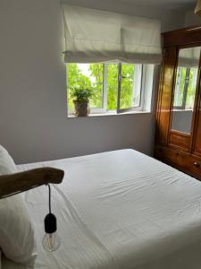 a bedroom with a white bed with a window at Midcentury modern 1 bedroom apartment in Tirana in Tirana