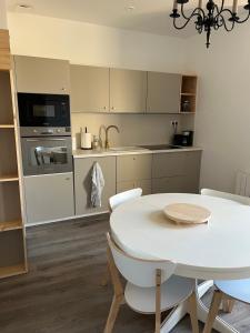 a kitchen with a white table and a white table and chairs at Escapade en Baiocensis in Villiers-le-Sec