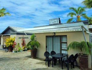 a building with a table and chairs in front of it at Kennington Palms B&B/Self Catering in East London
