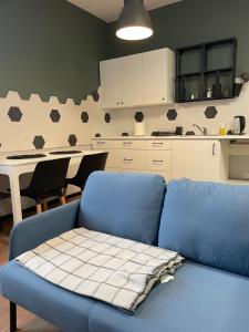 uma sala de estar com um sofá azul e uma cozinha em Apartamenty Medyka Park em Medyka