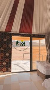 a bedroom with a view of the desert through a window at Rum city Star LUXURY Camp in Wadi Rum