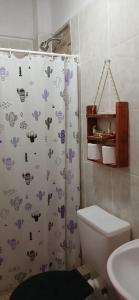 uma casa de banho com uma cortina de chuveiro e um WC em Hospedaje Puntos Cardinales em Purmamarca