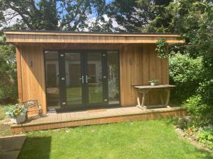 a small cabin with a table in the grass at Gladstone Avenue Twickenham in Twickenham