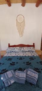 uma cama com três almofadas em cima em Hospedaje Puntos Cardinales em Purmamarca