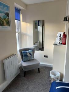 einen Stuhl in einem Zimmer mit Spiegel in der Unterkunft Seagull Cottage in Looe