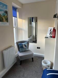 a chair sitting in a room with a mirror at Seagull Cottage in Looe