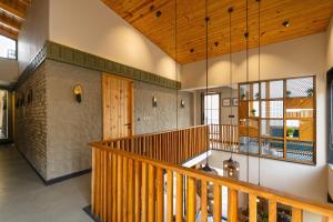 a staircase in a house with a wooden ceiling at SaffronStays Aruunoday - Villa 4 bhk and 1 room Suite in Bhīm Tāl