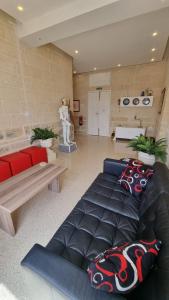 ein Wohnzimmer mit einem schwarzen Ledersofa und einem Tisch in der Unterkunft Grand Harbour View in Valletta