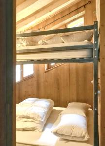 2 łóżka piętrowe w pokoju z drewnianymi ścianami w obiekcie Appartement de 3 chambres avec jardin clos et wifi a Peisey Nancroix w mieście Peisey-Nancroix