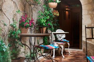 馬賽的住宿－馬斯維勒酒店，庭院设有两把椅子和一张鲜花桌子