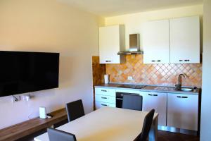 a kitchen with a table and a tv in a room at bilocale Murta maria in Olbia