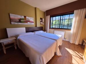 Łóżko lub łóżka w pokoju w obiekcie Hostal O Galeón San Luis