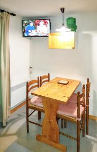 a wooden table with chairs and a television on the wall at Studio avec balcon a Vallandry in Landry