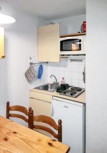 a small kitchen with a sink and a stove at Studio avec balcon a Vallandry in Landry
