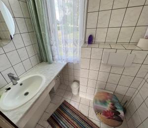 a white bathroom with a sink and a toilet at Ferien-Bungalow im Seebad UeckermündeOT Bellin in Ueckermünde