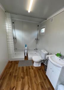 a bathroom with a toilet and a tub and a sink at Ferien-Bungalow im Seebad UeckermündeOT Bellin in Ueckermünde +6 photos