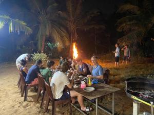 a group of people sitting around a table with a fire at Mekong Delta Homestay Family Tiny Garden in Bến Lức