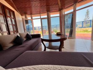 ein Wohnzimmer mit einem Sofa und einem Tisch in der Unterkunft Ocean Dunes House in Tamelalt