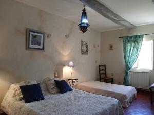 a bedroom with two beds and a pendant light at Le Mas des Baux in Bédoin +67 photos