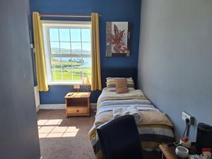 Habitación pequeña con cama y ventana en Rathmore House Bed & Breakfast en Baltimore