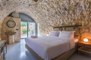 a bedroom with a large bed in a stone wall at Amani Luxury 4-Bedroom Villa & Pool in Batroun in Batroûn +78 photos