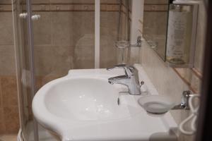 a white sink in a bathroom with a shower at Hotel President in Montecatini Terme