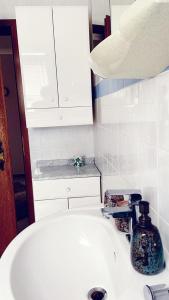 a white bathroom sink with a blue bottle on it at IIA Apartments in Warzen +18 photos