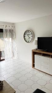 a living room with a clock on the wall at IIA Apartments in Warzen