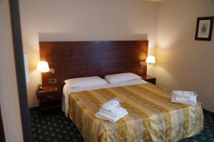 ein Hotelzimmer mit einem Bett mit Handtüchern darauf in der Unterkunft Hotel President in Montecatini Terme