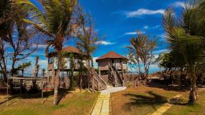 un complejo con un parque infantil con una torre y palmeras en Ocas do Índio Hotel Spa, en Beberibe