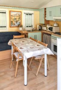 cocina con mesa y sillas en Bungalow de 2 chambres a Cauterets a 900 m des pistes avec jardin amenage et wifi en Cauterets