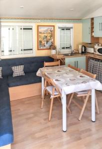 cocina y comedor con mesa y sillas en Bungalow de 2 chambres a Cauterets a 900 m des pistes avec jardin amenage et wifi en Cauterets