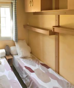 Habitación pequeña con 2 camas y ventana en Bungalow de 2 chambres a Cauterets a 900 m des pistes avec jardin amenage et wifi en Cauterets