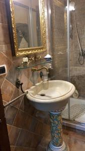 a bathroom with a sink and a mirror and a shower at L'Antico Loco Commodo in Viterbo