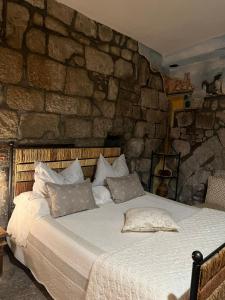 a bedroom with a large bed in a stone wall at L'Antico Loco Commodo in Viterbo