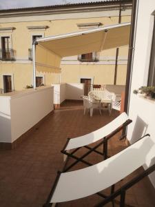 uma varanda com cadeiras e uma mesa num edifício em B&B La Terrazza em Cetraro