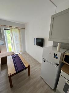 uma cozinha com um frigorífico e uma mesa num quarto em Myklebostad em Steigen