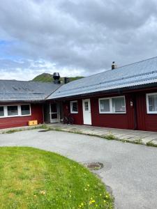 a red house with a driveway in front of it at Myklebostad in Steigen