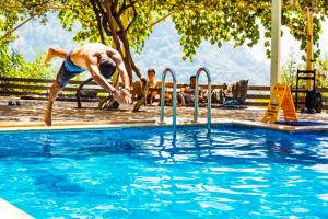 a man is jumping into a swimming pool at Fullmoon Camp in Faralya