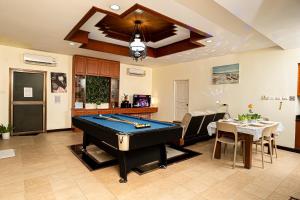 a living room with a pool table and a dining room at F&K Pool Villa Pattaya in Jomtien Beach