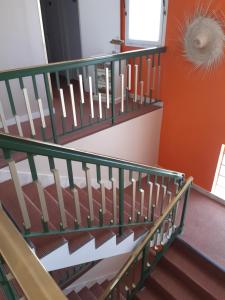 a staircase with green railings and orange walls at Hôtel Ker-Noyal Quiberon Plage in Quiberon