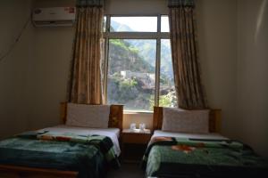 two beds in a room with a large window at Besham Inn, Besham in Besham +135 photos