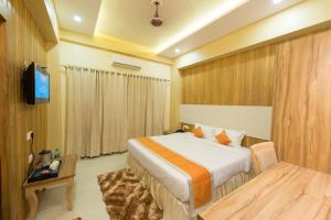 a hotel room with a bed and a television at Hotel Ratana International in Lucknow