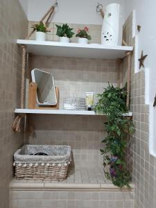 uma casa de banho com prateleiras com plantas e um espelho em Cosy Space Apartment em Tychy